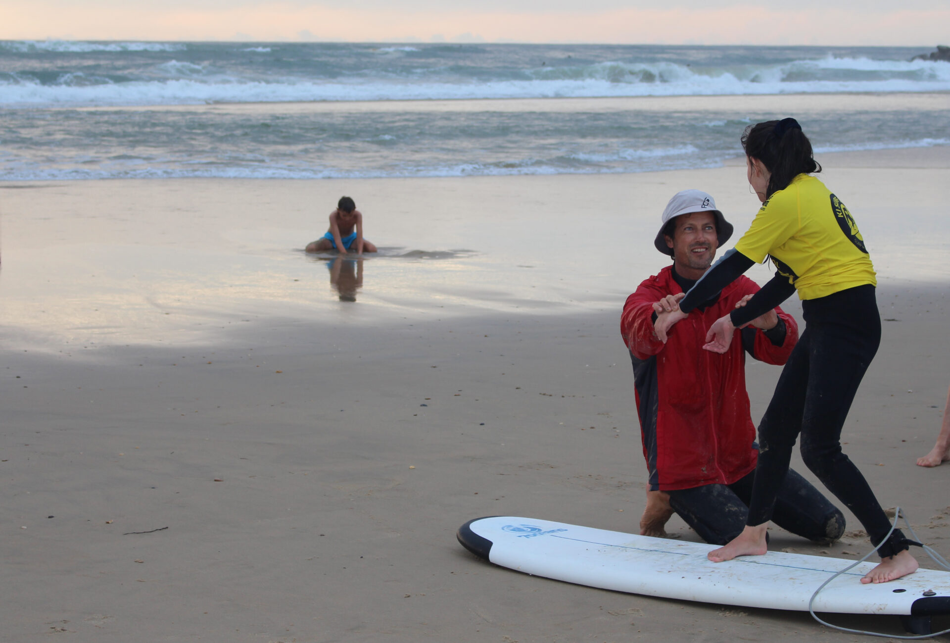 Moniteur de surf enseignant à une élève sur la plage à Capbreton