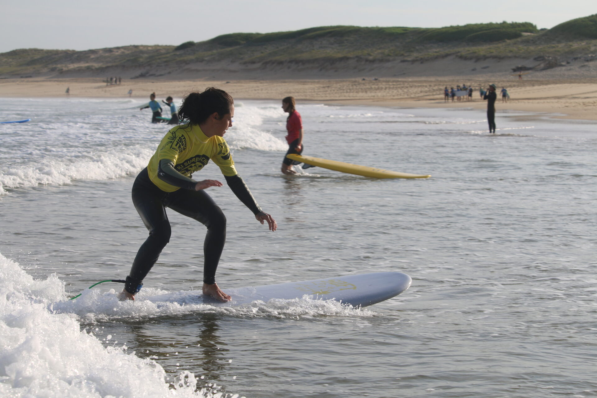 Élève surfeuse, surfant avec une planche blanche, stage surf