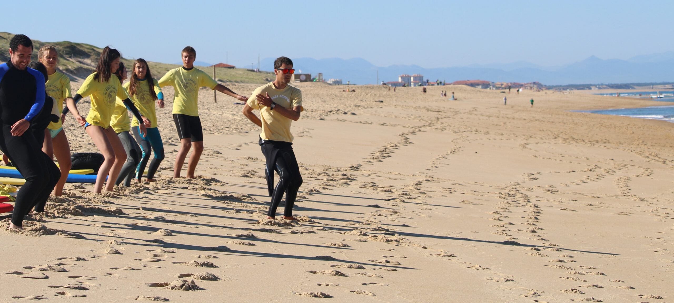 Groupe de surfeurs s'échauffant sur la plage avant de vérifier L'indice de flottabilité.
