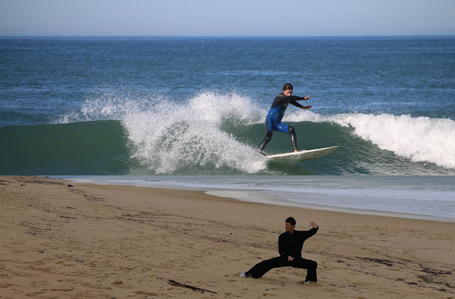 Surfer auf einer Welle, Tai Chi am Strand.
