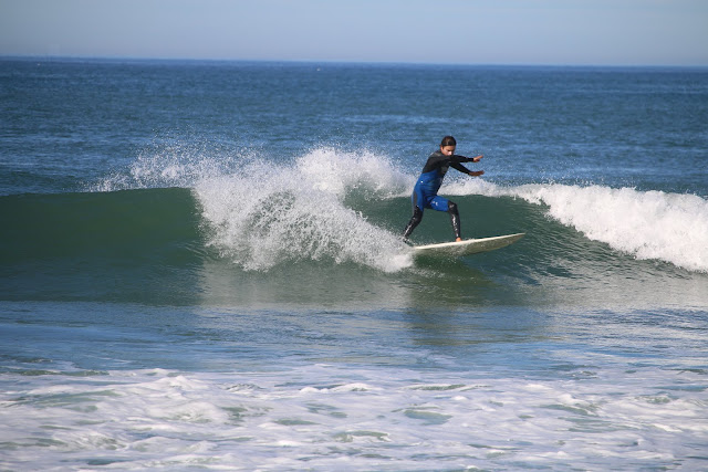 Surfeur en combinaison surfant sur une vague verte