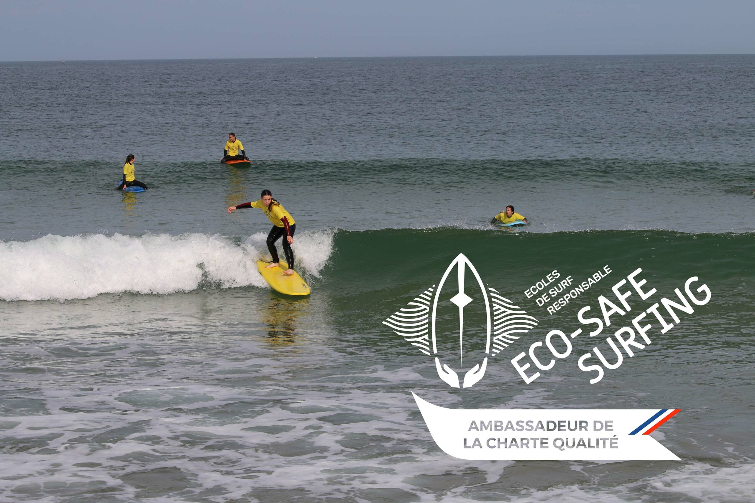 Des surfeurs apprennent à surfer sur des vagues douces, avec le logo Eco-Safe Surfing.
