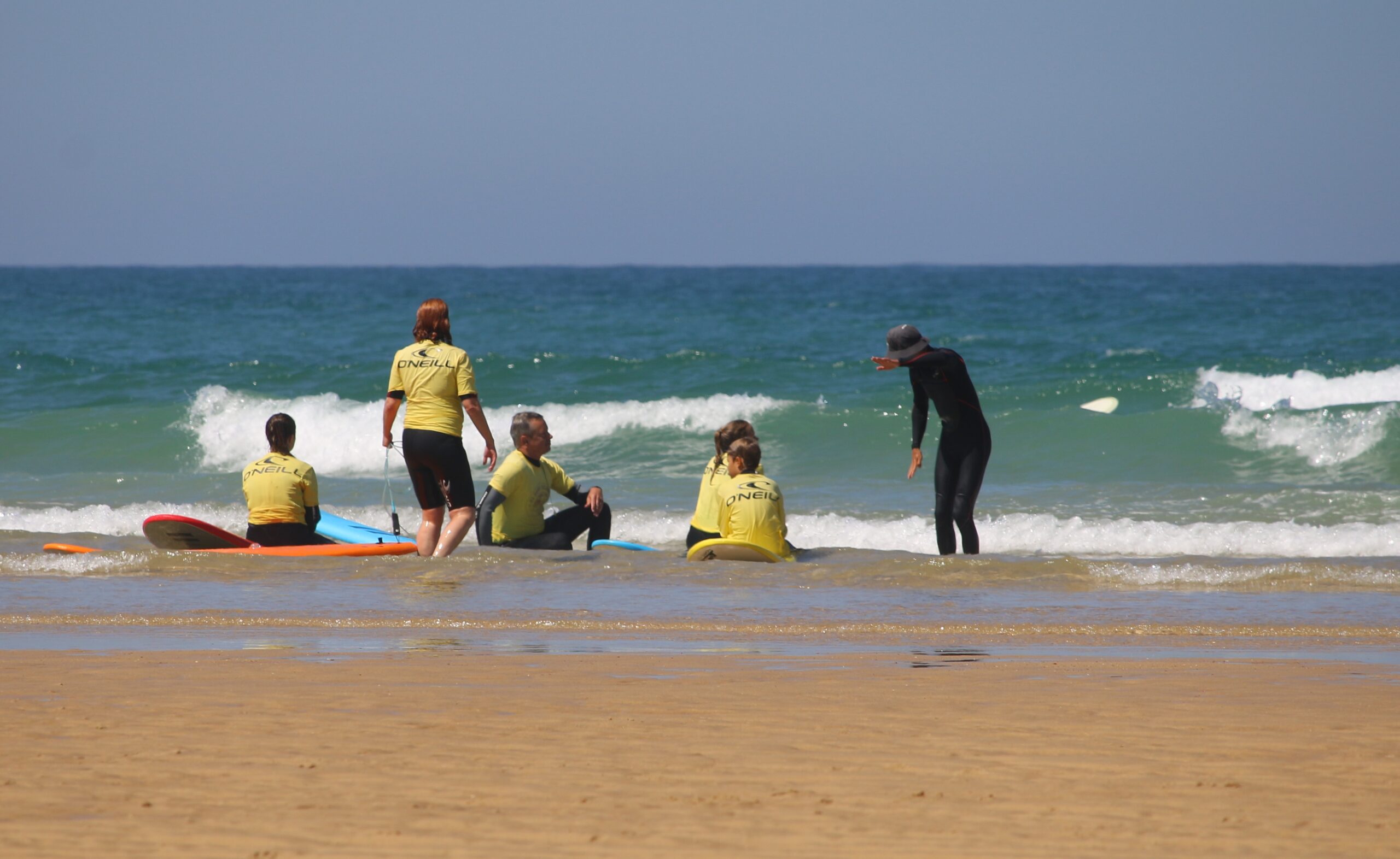 Cours de surf : instructeur guidant des élèves sur la plage